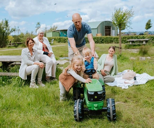3 generaties zitten buiten in het gras