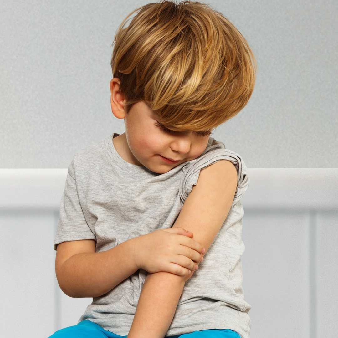 Kind die naar zijn bovenarm kijkt